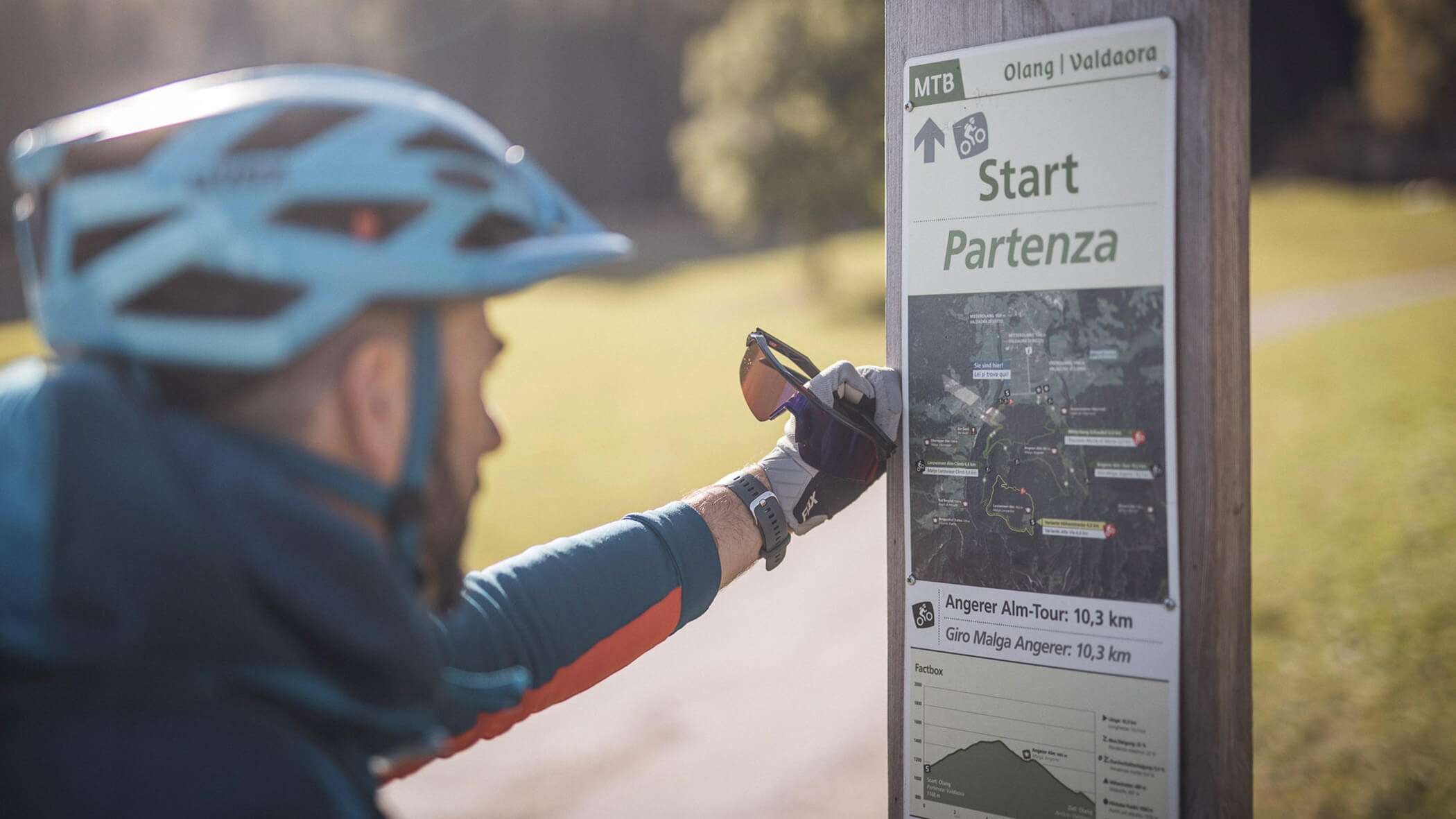 Radfahrer schaut auf Routenkarte von Olang - Bad Bergfallerhof