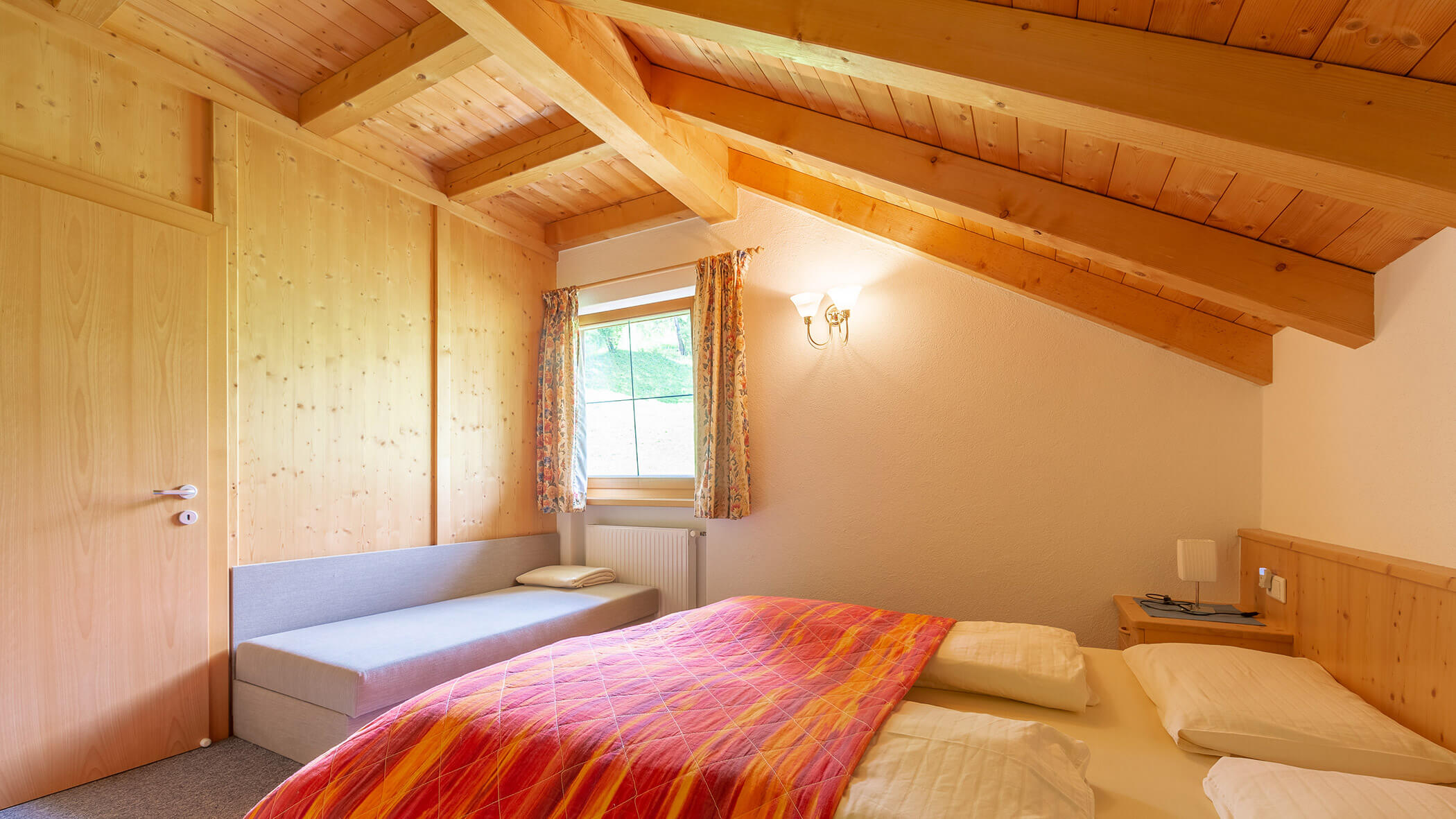 Schlafzimmer mit Doppelbett und Schlafsofa in der Ferienwohnung Typ A - Bad Bergfallerhof